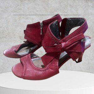 Red Leather Heeled Sandals With Ankle Straps and a Bow Accent.